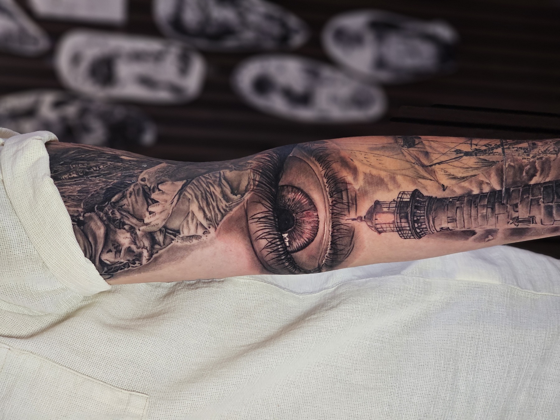 Auge und Leuchtturm als surrealistische Black-&-Grey-Komposition – Realistic Tattoo von Lucas Schenk in Rothenburg bei Luzern