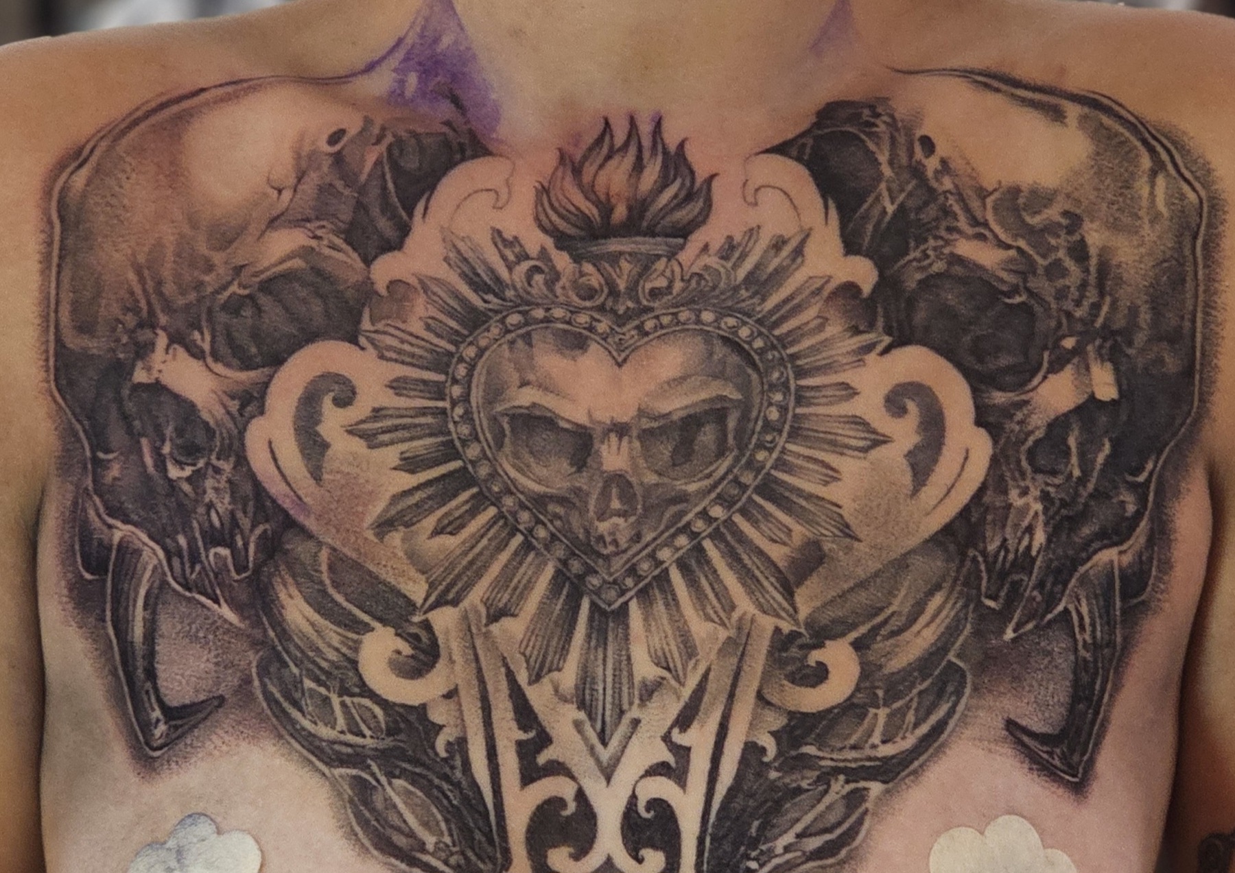Düstere Sacred-Heart-Komposition mit Schädeln und symmetrischen Ornamenten als Custom-Tattoo – Stiplerealismus Tattoo von Lucas Schenk in Rothenburg bei Luzern